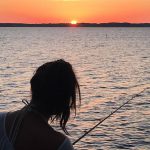 Woman fishing at sunset