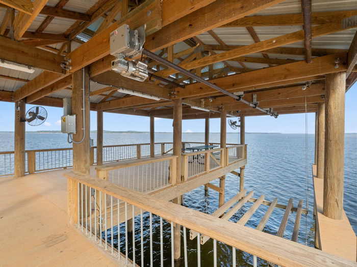 Inside the boathouse is a single boat lift that has been configured with multiple runners, making it able to lift either a bass boat, bay boat, and pontoon boats including tri-toons.