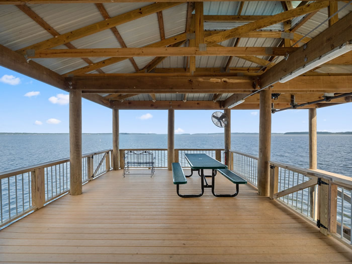 Just to the left of the boat lift is a gathering area that has a picnic table and a small glider for two people. This area is perfect for catching evening sunsets.